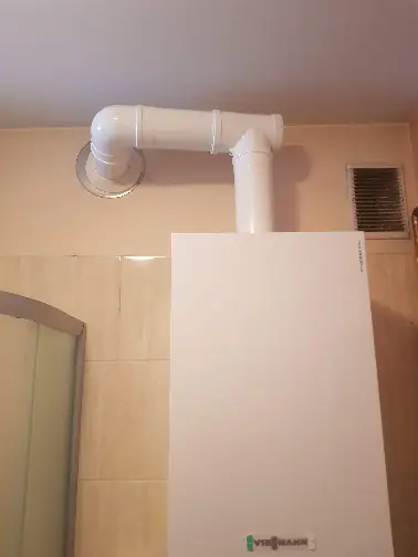Montaż nowoczesnego pieca gazowego kondensacyjnego Viessmann w łazience z systemem odprowadzania spalin.